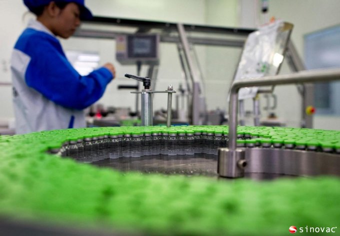 a worker inspects vials containing H5N1 flu vaccine produced by Beijing-based drug maker Sinovac Biotech Ltd. in Beijing